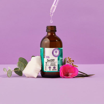 Eine Pipette über einem ZecOFF – Zecken & Lästlinge von FAVLY Petfood mit natürlichen Ölen auf violettem Hintergrund.