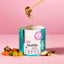 Ein Löffel FAVLY Petfood FloraVITAL Pulver - Verdauung & Darmflora inmitten von Kräutern auf Pink, für die Darmgesundheit.