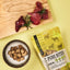 FAVLY Petfood PURE Bites Lamm auf einem Brett, Snacks in einer Schale und der Beutel auf gelbem Hintergrund.